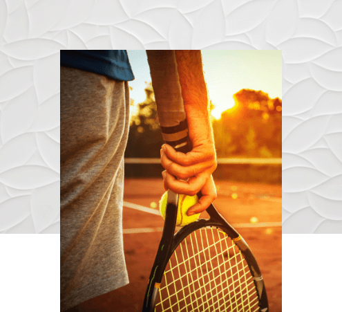 Person in tennis court holding a racket and tennis ball