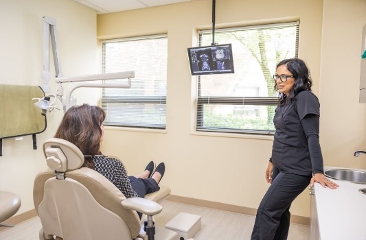 Doctor James talking to a patient in the dental chair