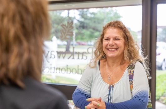 Woman smiling at receptionist in Lorain dental office