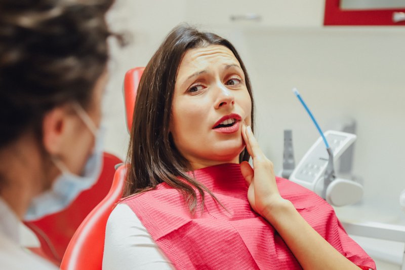 An upset young woman seeing her dentist for a root canal